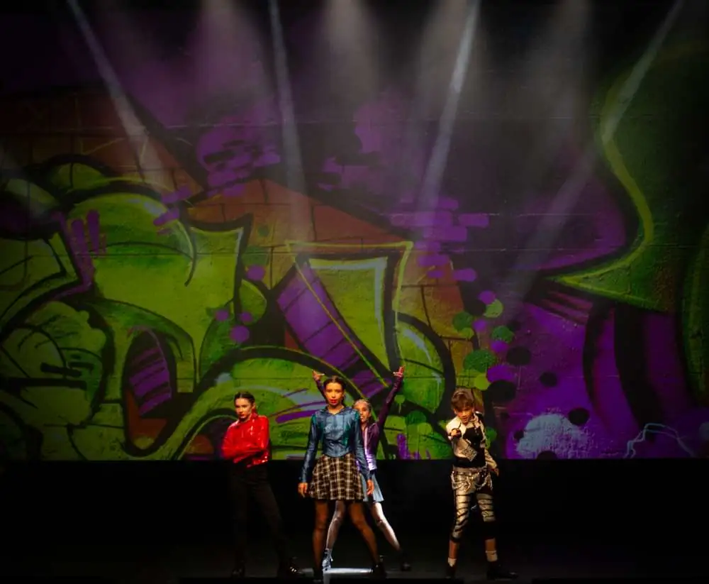 A small group in front of a graffiti wall
