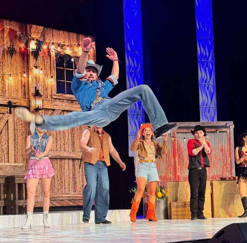 A dancer flying through the air in a high kick