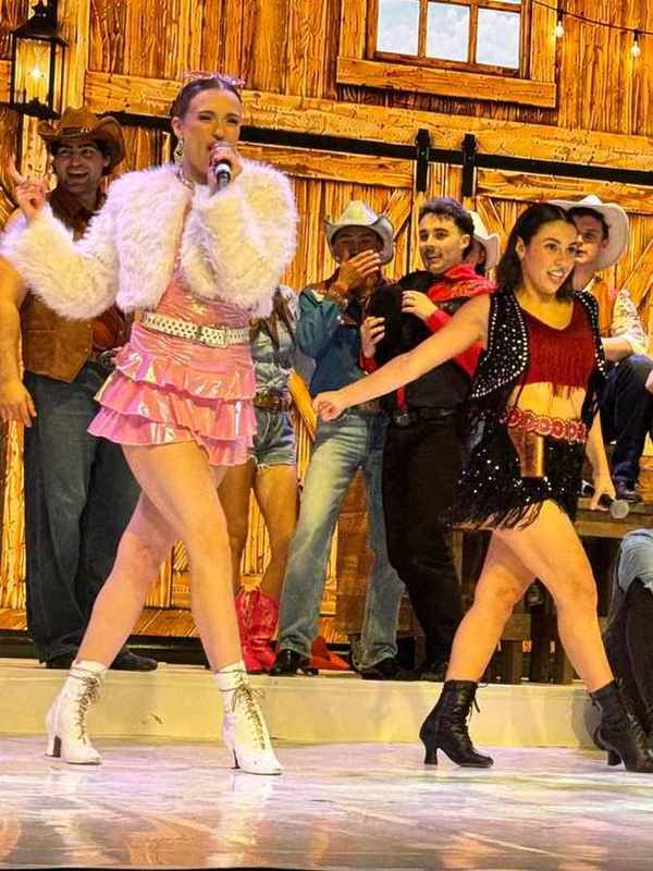 A singer in a fluffy white jacket and pink ruffle skirt