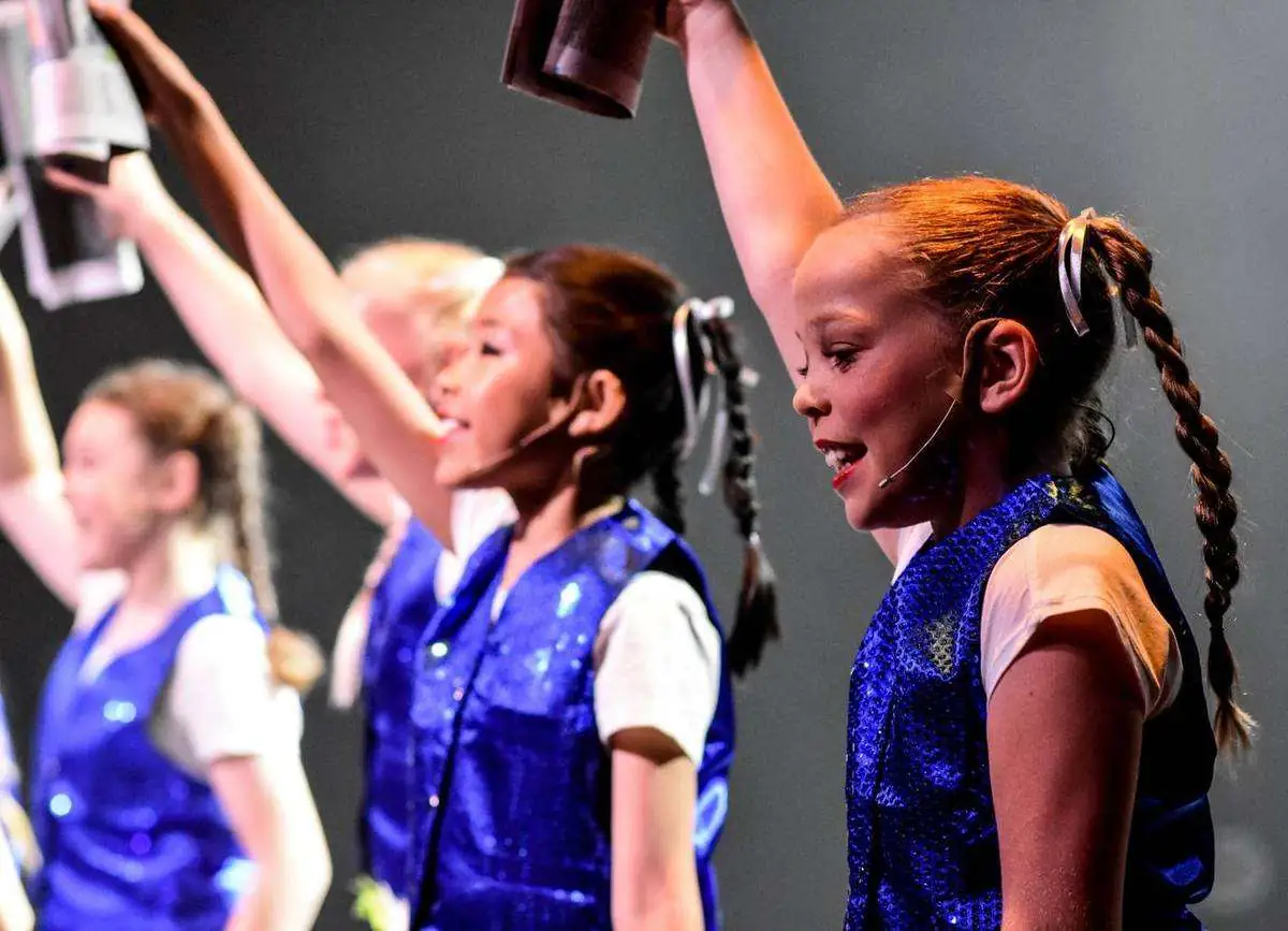 Young Spotlight performers with arms in the air
